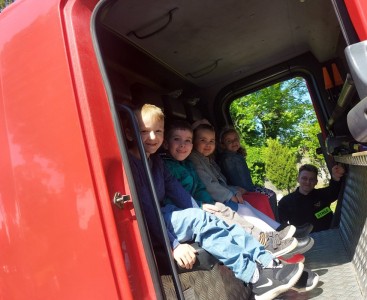 Zdjęcie przedstawia dzieci w wozie strażackim. - powiększ