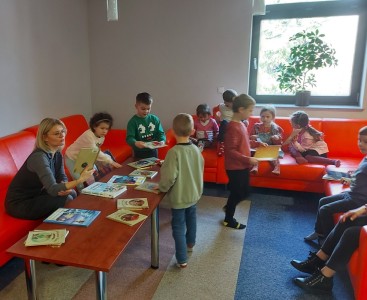 Zdjęcie przedstawia dzieci podczas odwiedzin w Bibliotece Publicznej. - powiększ