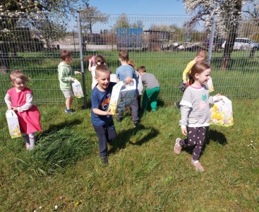 Zdjęcie przedstawia dzieci szukające prezentów od Zajączka. - powiększ