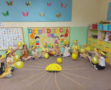 Zdjęcie przedstawia dzieci z wykonanym słoneczkiem z okazji Dnia Dziecka. - powiększ