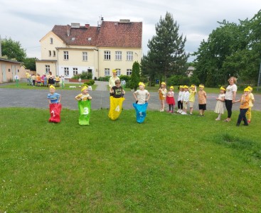 Na zdjęciu dzieci skaczą w workach. - powiększ