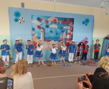 Zdjęcie przedstawia dzieci w trakcie występu z okazji Dnia Mamy i Taty. - powiększ