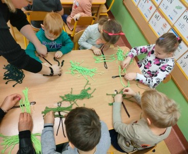 Dzieci na warsztatach robiące choinki. - powiększ