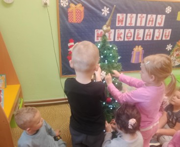 Dzieci podczas ubierania choinki. - powiększ