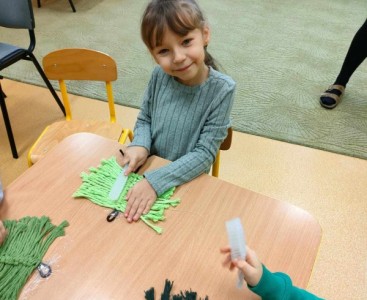 Dziecko podczas warsztatów makramy. - powiększ