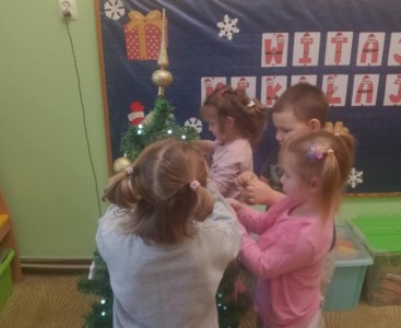 Dzieci podczas ubierania choinki. - powiększ