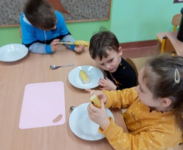Dzieci obierają banana  - powiększ