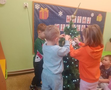 Dzieci podczas ubierania choinki. - powiększ