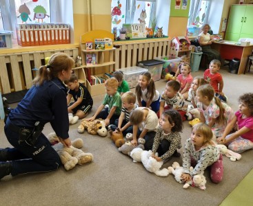 Policjantka demonstruje dzieciom zasady resuscytacji na pluszowym misiu. - powiększ