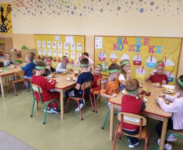 Zdjęcie przedstawia dzieci w trakcie degustacji pieczonego jabłka. - powiększ