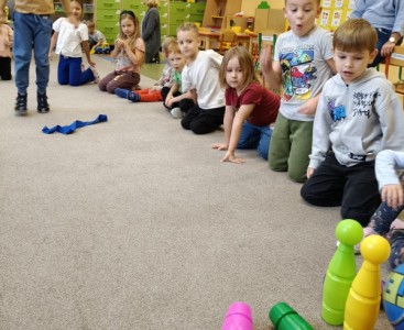 Zdjęcie przedstawia dzieci w trakcie konkurencji sportowych z okazji Dnia Chłopaka. - powiększ