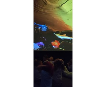 Zdjęcie przedstawia dzieci w trakcie seansu filmowego 'Oceanarium'. - powiększ