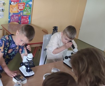 Zdjęcie przedstawia dzieci oglądające okazy przez mikroskopy - powiększ