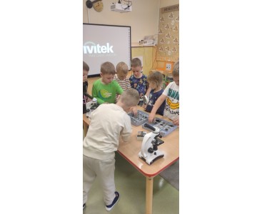 Zdjęcie przedstawia dzieci oglądające okazy przez mikroskopy i lupy - powiększ