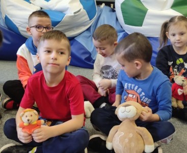 Zdjęcie przedstawia przedszkolaki z pluszowymi misiami. - powiększ