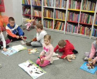 Zdjęcie przedstawia dzieci oglądające książeczki.  - powiększ