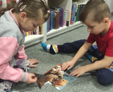 Na zdjęciu ukazano dzieci układające puzzle ,,Misiowe rodzinki'. - powiększ