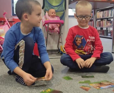 Na zdjęciu ukazano dzieci układające puzzle ,,Misiowe rodzinki'. - powiększ