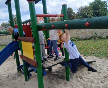 Na zdjęciu dzieci w trakcie zabawy na placu zabaw - powiększ