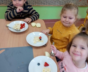 Dzieci jedzą sałatkę  - powiększ